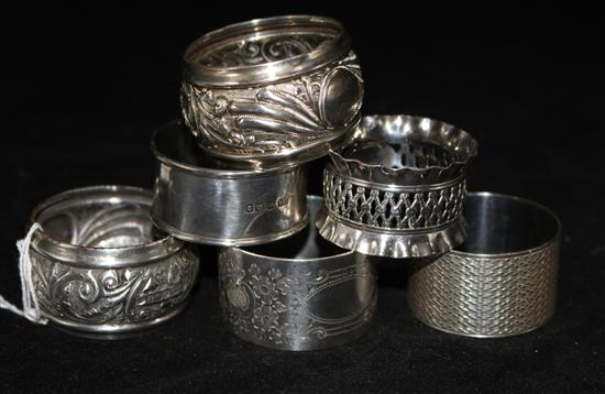 A pair of silver napkin and four other assorted silver napkin rings.